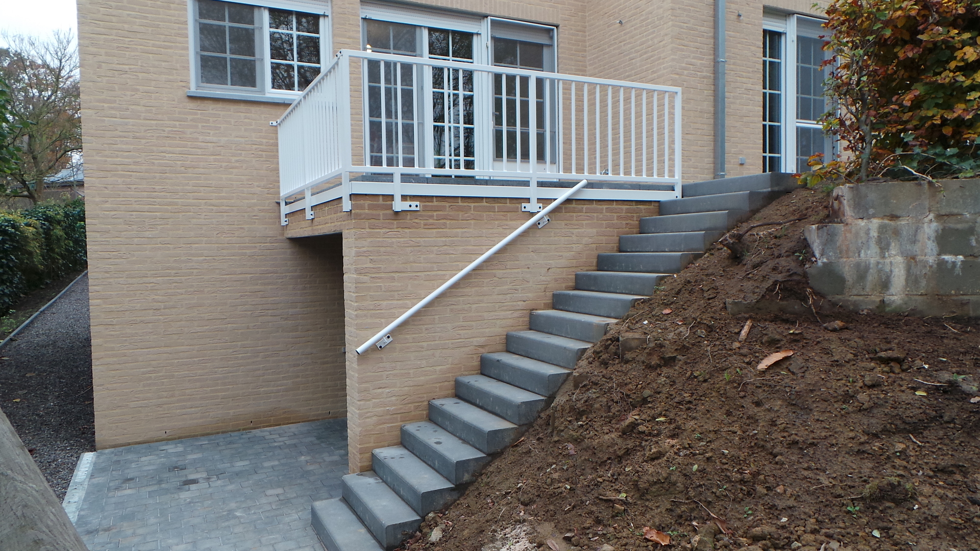 Balustrade met verticale spijlen en handgreep tegen de muur.