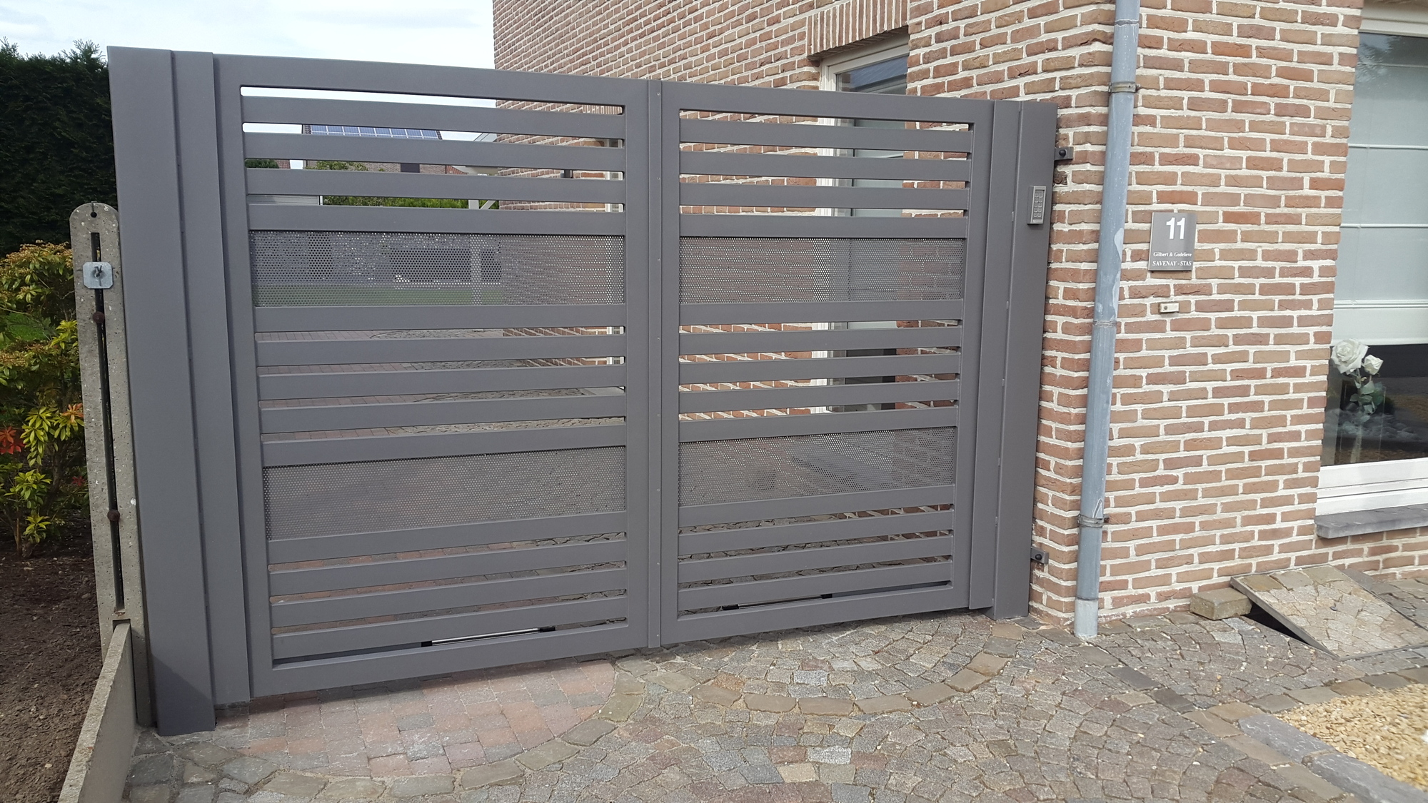 Moderne poort met horizontale latten en perfo plaat